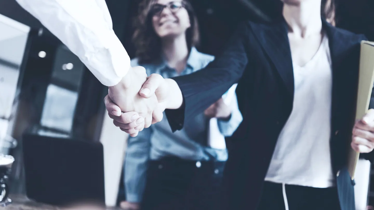 Two people in business meeting shaking hands