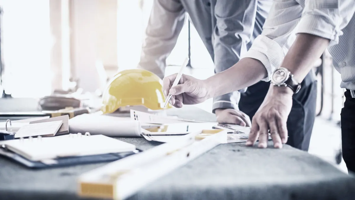 Två hantverkare som diskuterar en ritning