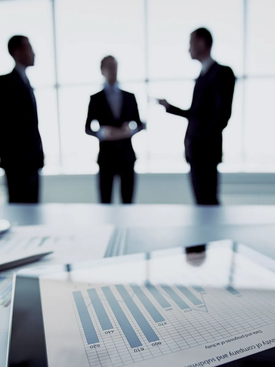 Three business men disussing something in the blurry background