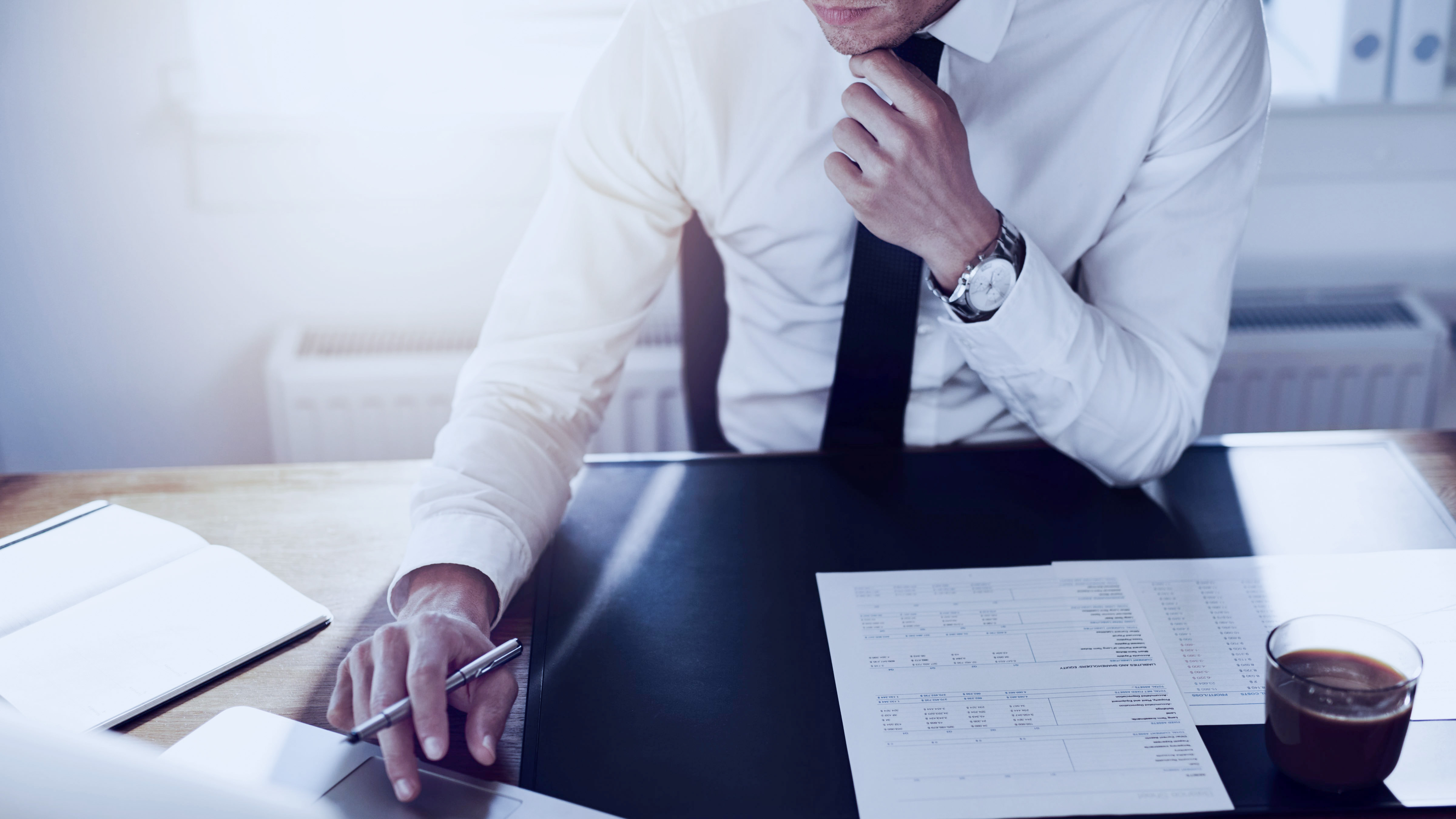 Man sitter framför laptop vid sitt skrivbord 